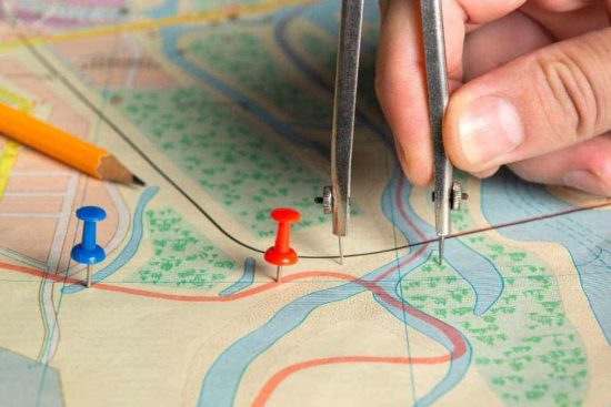 Sheds in Georgia - Colorful map with red push pins and a fair-skinned hand holding a compass