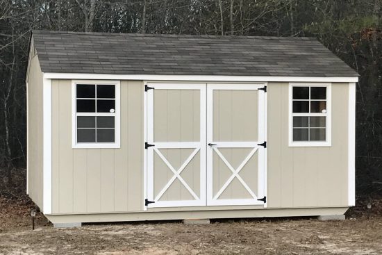 One of our Beige utility sheds in Cordele GA with white-trimmed double doors and windows under charcoal gray roof