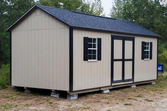 Painted beige and black shed - Beige painted wood siding with black trimmed double doors corners and windows under black shingled roof