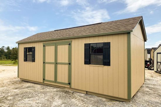 One of our beige garden sheds in McDonough GA - Beige painted siding with green-trimmed double doors and corners - two windows with black shutters under brown shingled roof