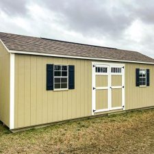 Side view of a beige Garden Shed Max with white trim and black shutters