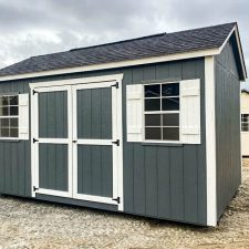 Gray 10x16 Garden Shed Max with white-trimmed double doors on open lot on cloudy day