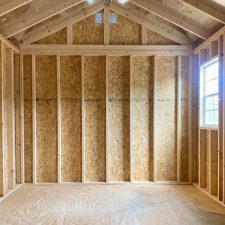 The interior of 10x16 Garden Shed Max, complete with open shelving - view of on window and partial view of door