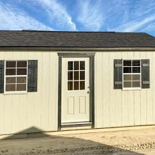 beige 12x20 Garden Shed Max with black window shutters and a single entry 9 lite door