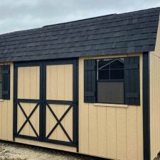 Exterior view of a beige and black 10x16 Garden Shed Max in Bonaire GA with barn-style double doors