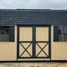 Exterior view of a beige and black 10x16 Garden Shed Max in Bonaire GA with barn-style double doors