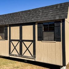 Exterior view of a beige and black 10x16 Garden Shed Max in Bonaire GA with barn-style double doors