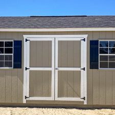 Beige 12x16 Garden Shed Max with white-trimmed double doors and two black-trimmed windows