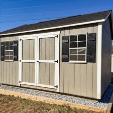 Beige 12x16 Garden Shed Max with white-trimmed double doors and two black-trimmed windows